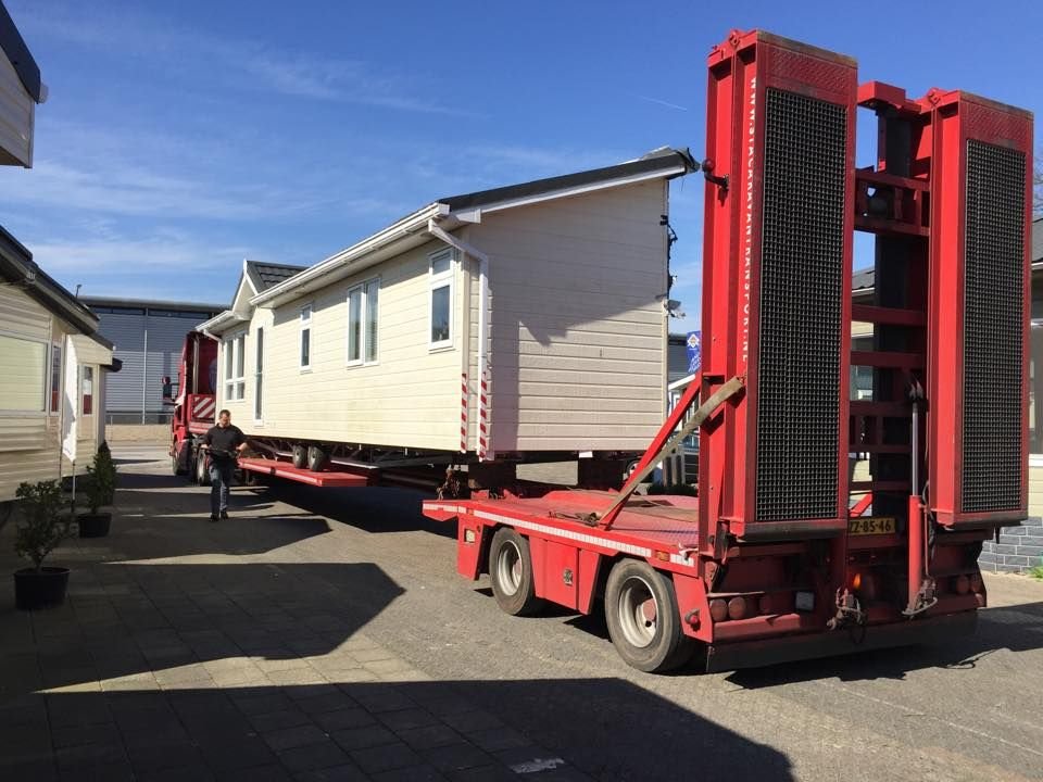 Mobile home being transported on a flatbed trailer by Dream Home Mover